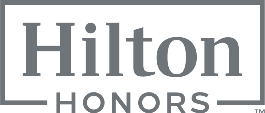 A Hilton Honors sign with a gray logo and framed border, reading &ldquo;Hilton&rdquo; large and &ldquo;HONORS&rdquo; beneath it, in muted tones. logo on footer section.