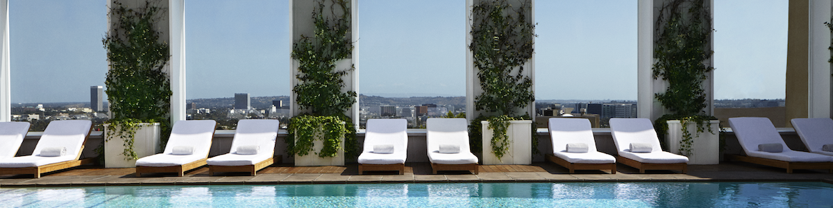 A luxurious rooftop pool area with white lounge chairs, potted trees, and large mirrors reflecting a city skyline in the distance, sunny and serene.