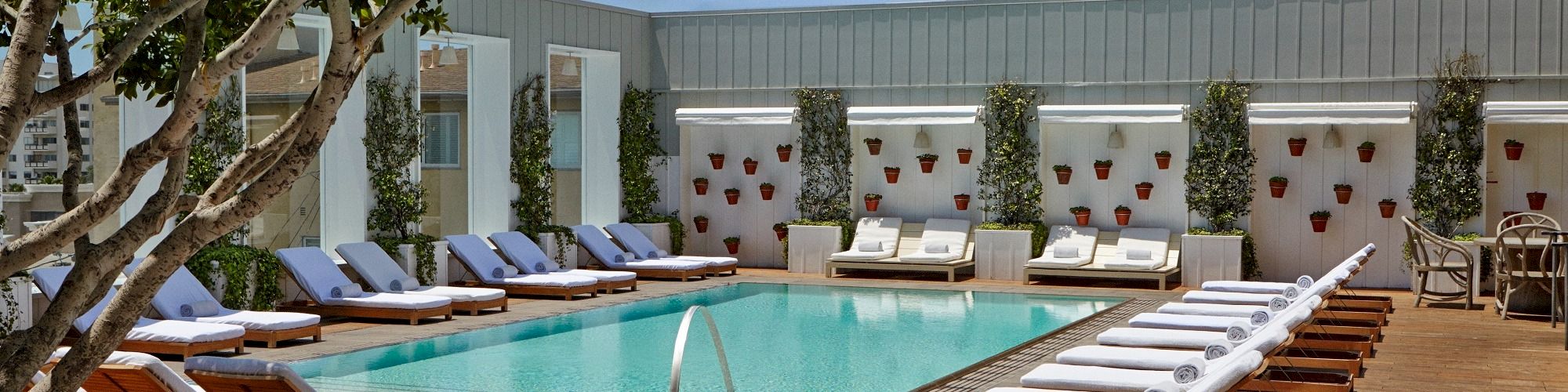 A sunny hotel pool area with lounge chairs, a rectangular pool, shaded cabanas, and a calm, resort-like vibe ending this sentence.