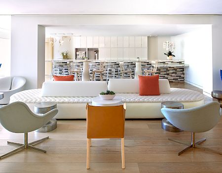 A bright, open lobby area with a white sofa, modern chairs, and Cafecito in the back.