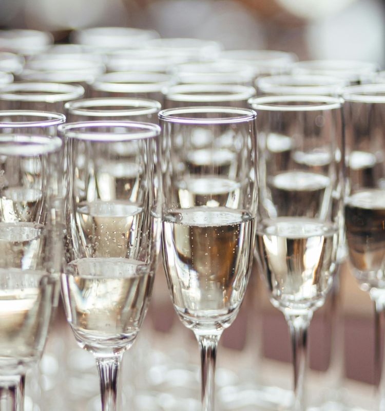 A row of champagne flutes filled with sparkling wine, ready for a toast at a celebration.
